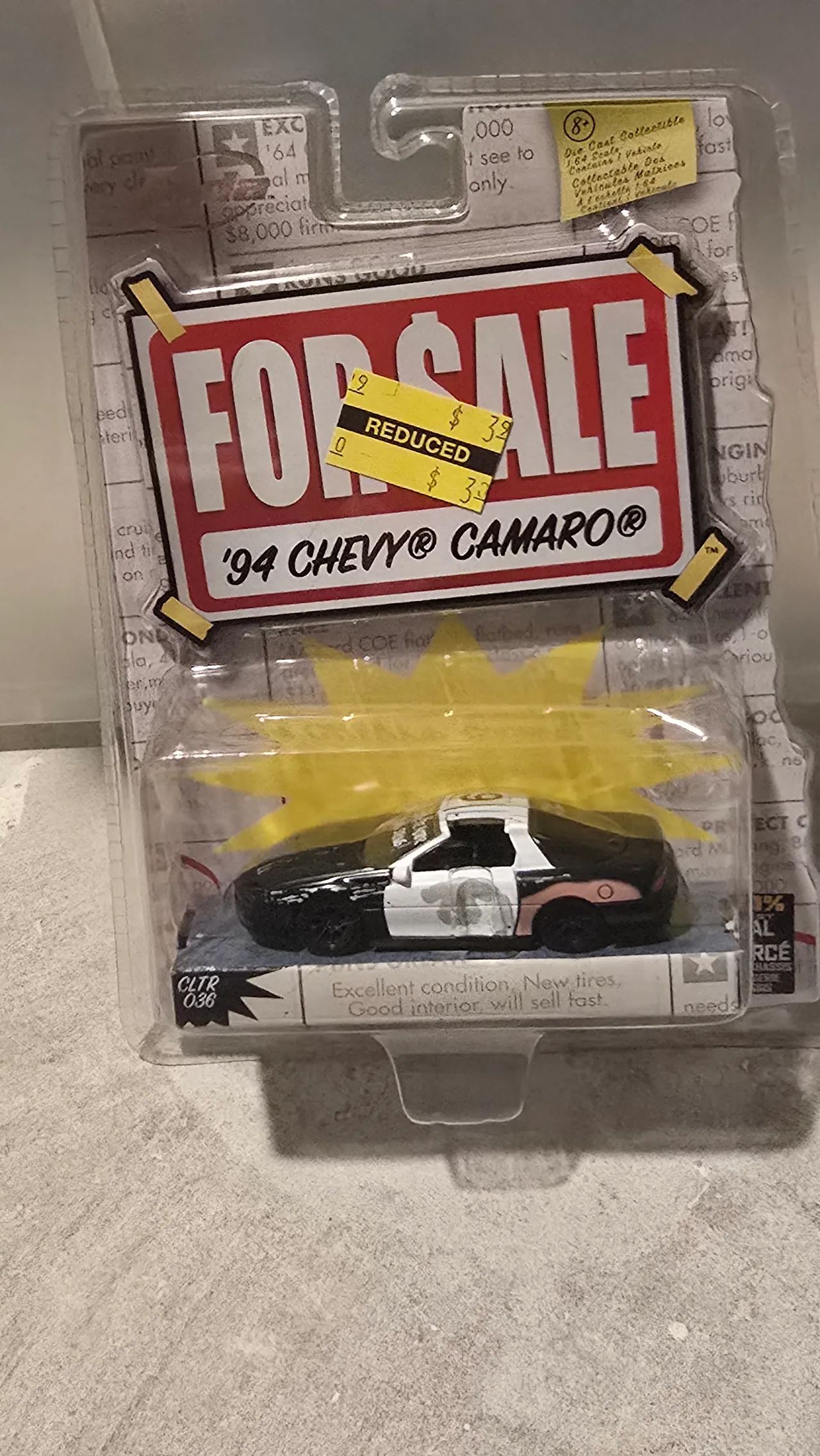 Weathered black and white 1994 Chevy Camaro police car by Jada Toys, For Sale, in its blister pack with a reduced-price sticker