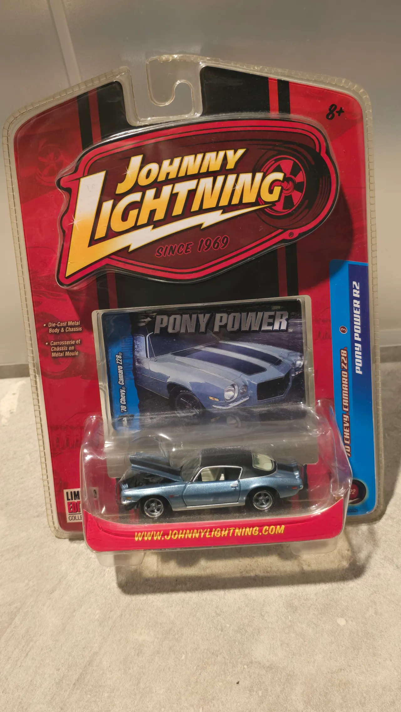 Light blue 1970 Chevy Camaro Z28 with a black roof and its hood open by Johnny Lightning, Pony Power, in its blister pack