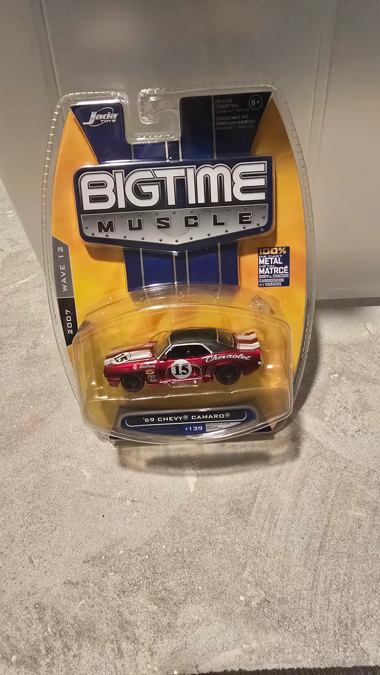 Candy red 1969 Chevy Camaro with a black roof and #15 race livery by Jada Toys, Big Time Muscle, in its blister pack