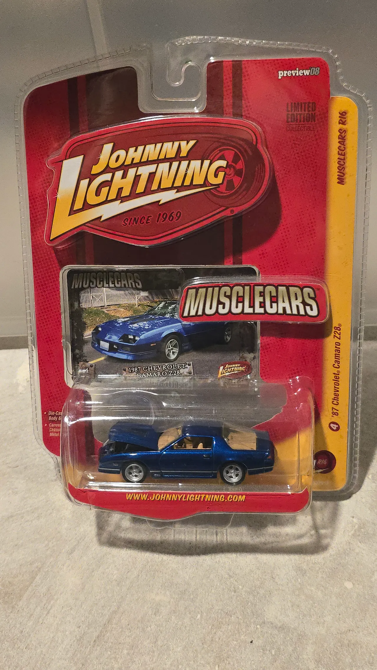 Blue 1987 Chevy Camaro Z28 with its hood open by Johnny Lightning, Musclecars, in its blister pack
