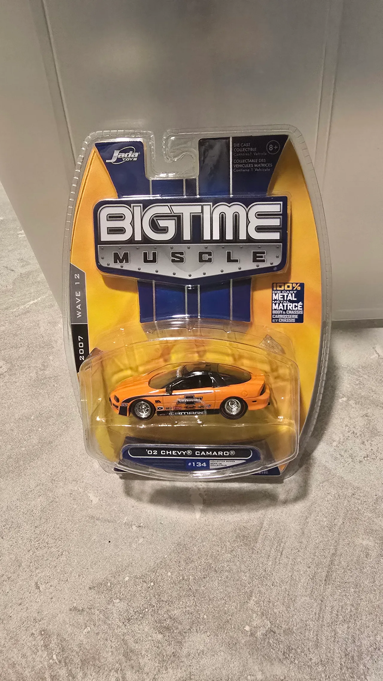 Orange 2002 Chevy Camaro SS with black accents and Chevrolet race decals by Jada Toys, Big Time Muscle, in its blister pack