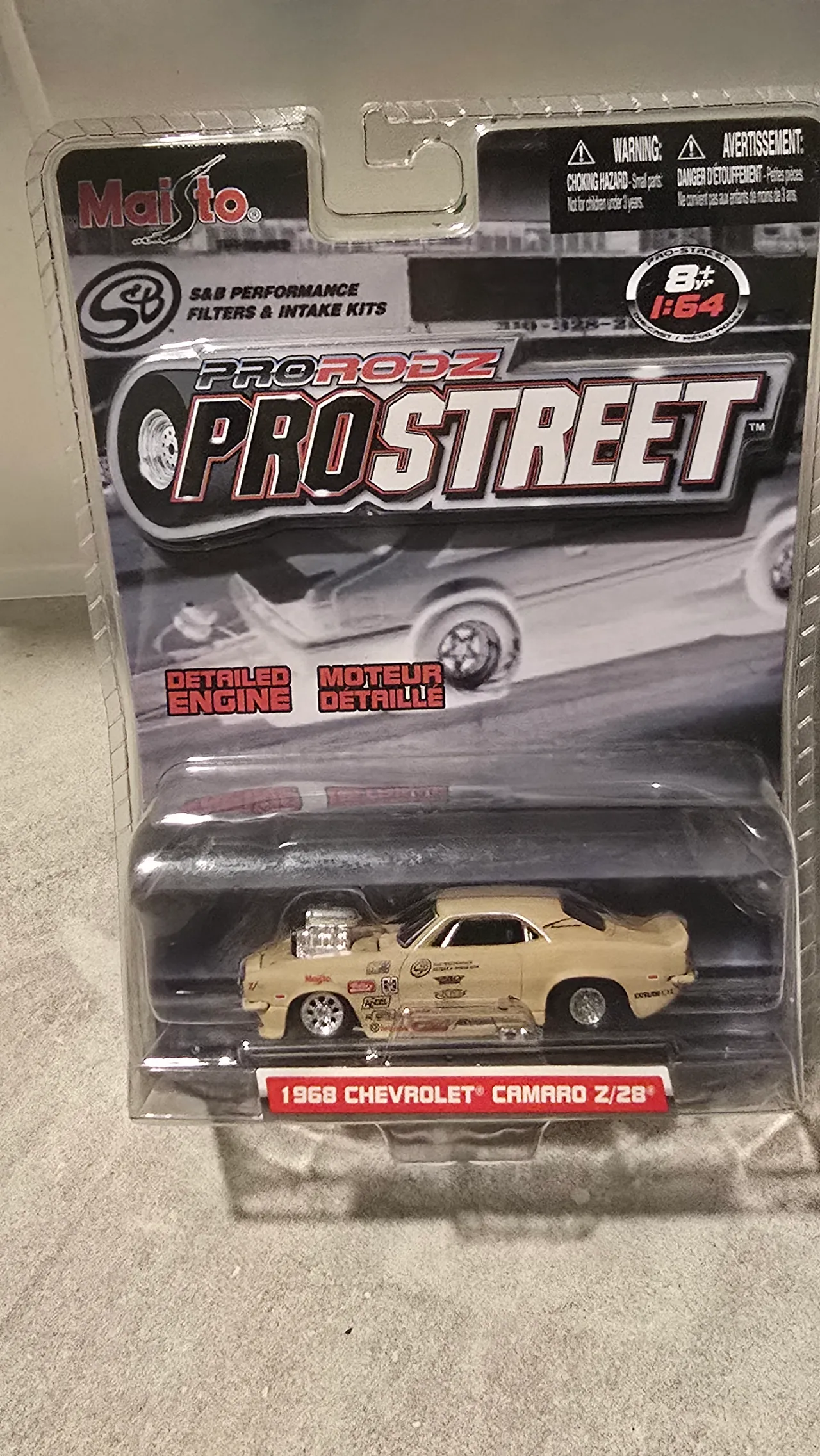 Cream 1968 Chevy Camaro Z/28 drag car with sponsor decals and a blower by Maisto, Pro Rodz Pro Street, in its blister pack