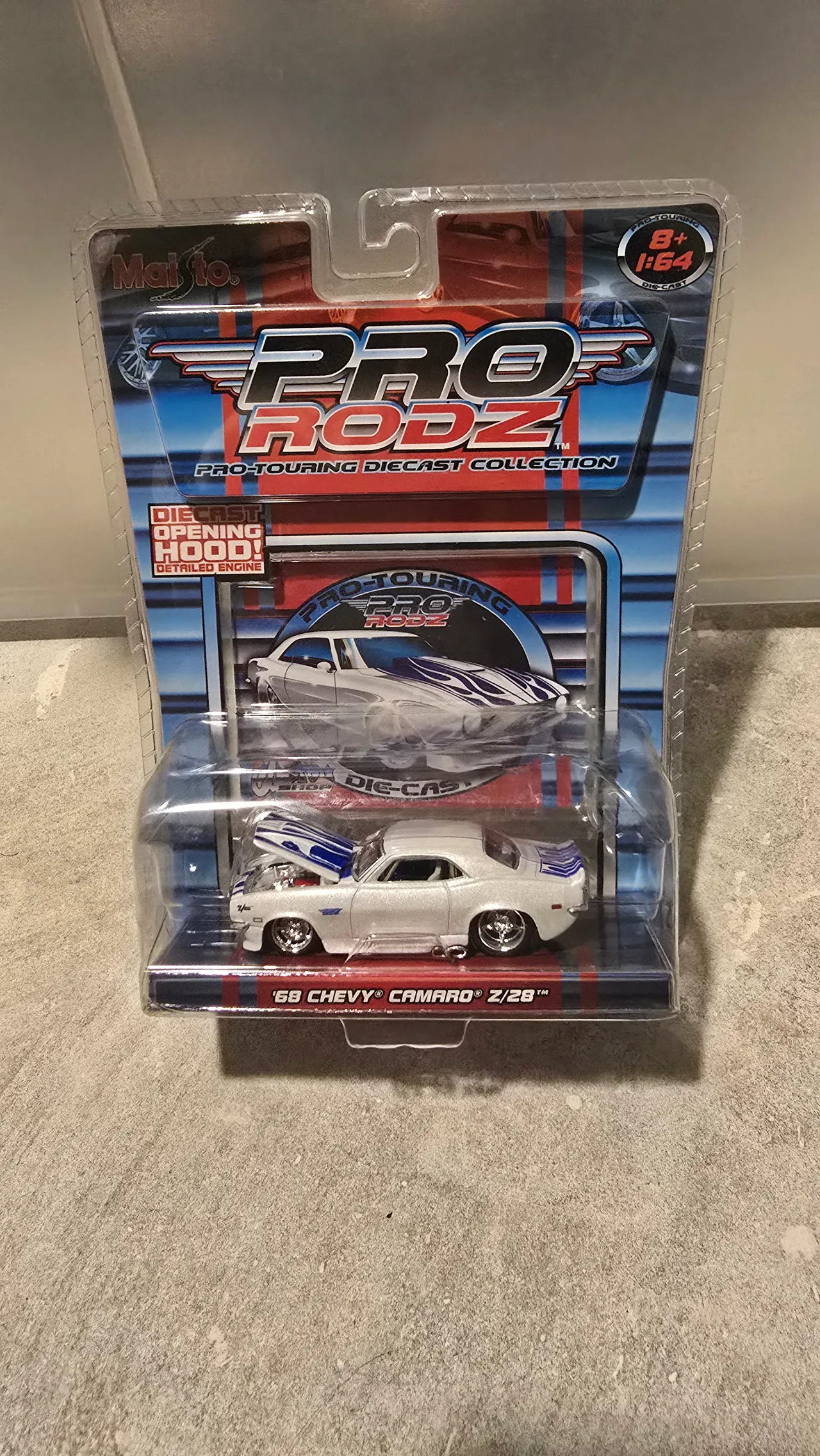 Pearl white 1968 Chevy Camaro Z/28 with blue flames and its hood open by Maisto, Pro Rodz Pro-Touring, in its blister pack