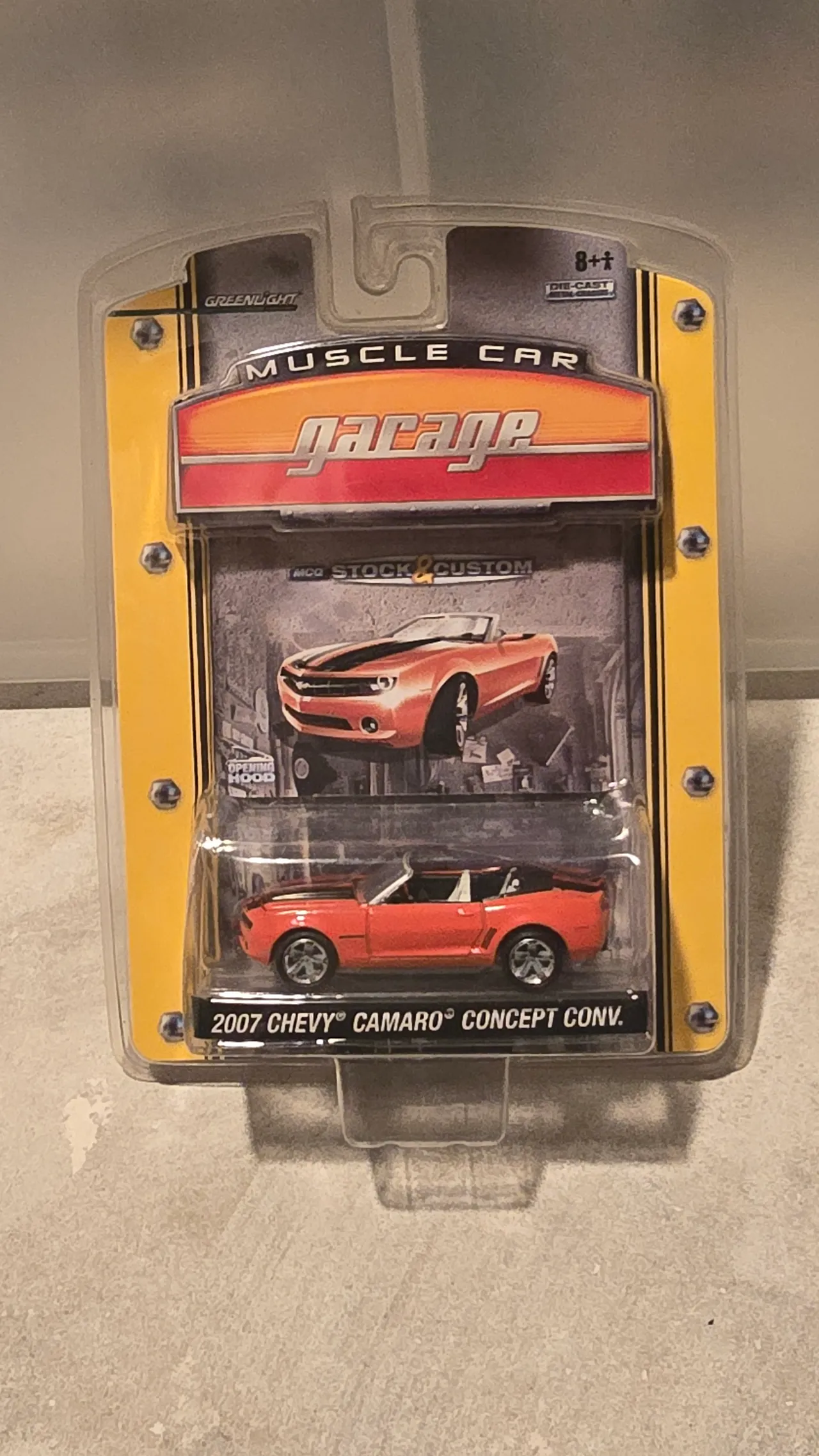 Orange 2007 Chevy Camaro Concept convertible with black stripes by Greenlight, Muscle Car Garage, in its blister pack