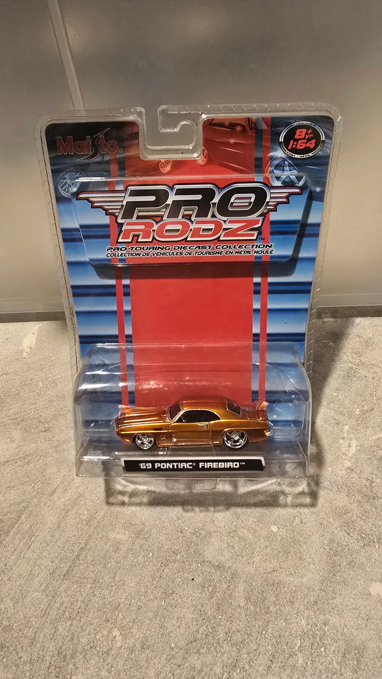 Metallic orange 1969 Pontiac Firebird with a rear spoiler by Maisto, Pro Rodz Pro-Touring, in its blister pack